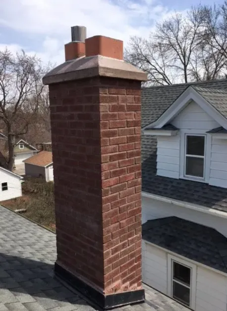 Tall red brick chimney with a concrete crown, two clay flue tiles and new base flashing